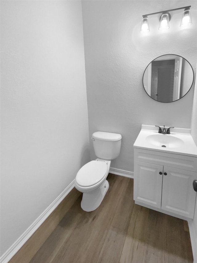 bathroom featuring vanity, hardwood / wood-style floors, and toilet