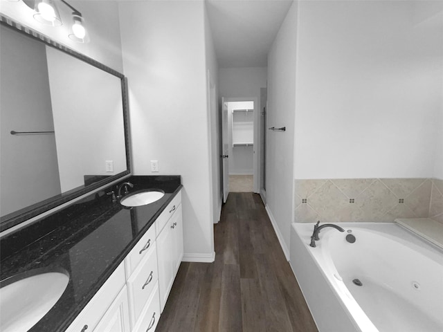 bathroom with vanity, hardwood / wood-style flooring, and a tub