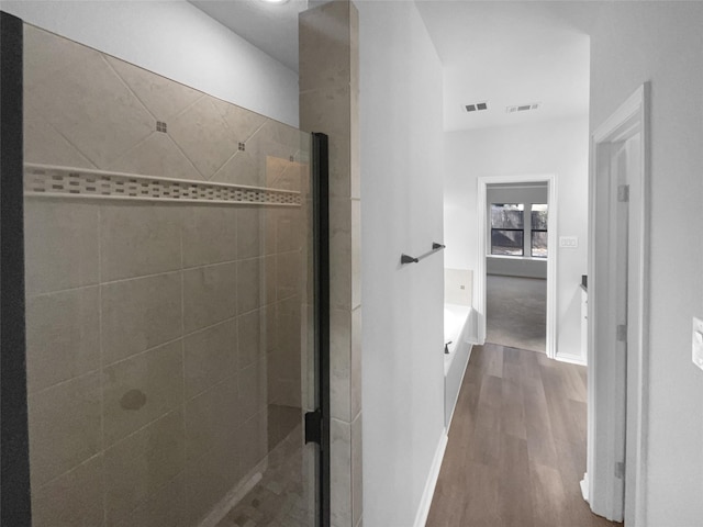 bathroom with hardwood / wood-style floors and an enclosed shower