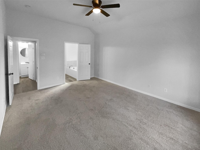 unfurnished bedroom featuring lofted ceiling, connected bathroom, ceiling fan, and carpet