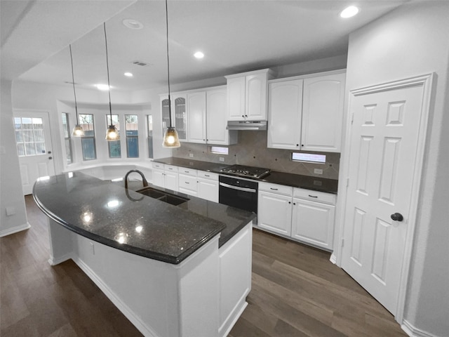 kitchen featuring white cabinetry, wall oven, sink, and pendant lighting