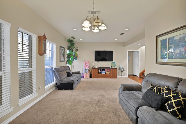 carpeted living room featuring an inviting chandelier