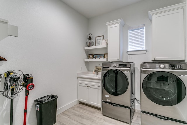 washroom with cabinets, sink, and washing machine and dryer