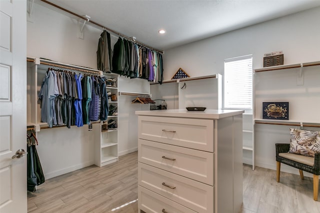 walk in closet with light hardwood / wood-style floors