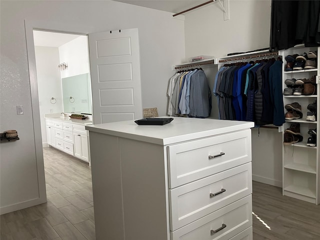 walk in closet with sink and light hardwood / wood-style flooring