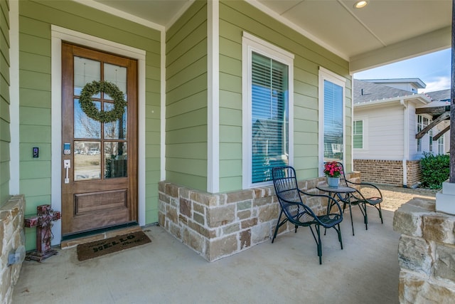 view of exterior entry featuring covered porch