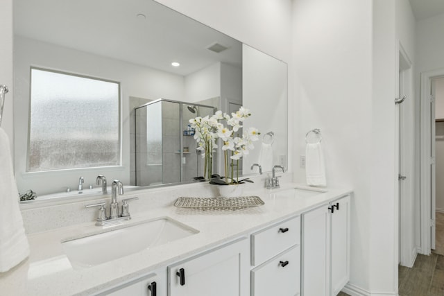 bathroom with a shower with door and vanity