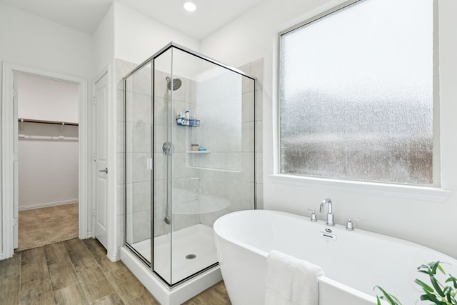 bathroom featuring hardwood / wood-style flooring and shower with separate bathtub