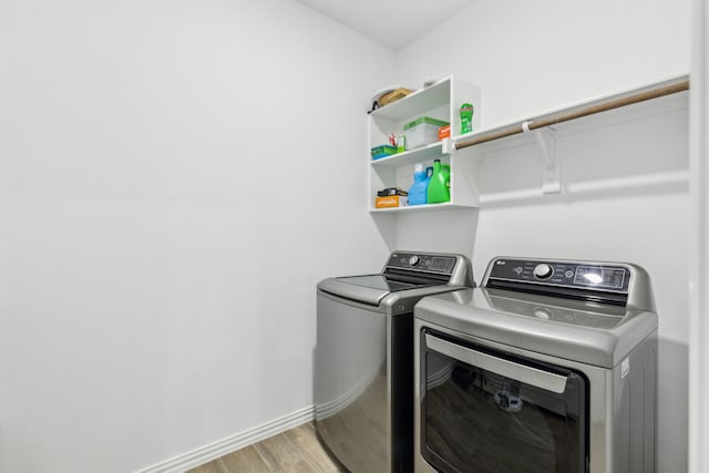 clothes washing area featuring washer and dryer and light hardwood / wood-style floors