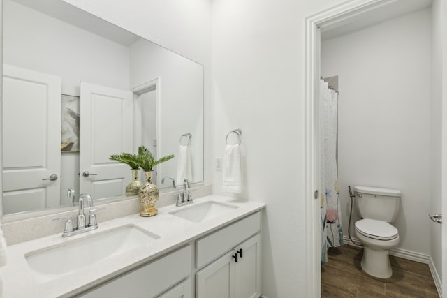 bathroom featuring vanity, hardwood / wood-style floors, and toilet