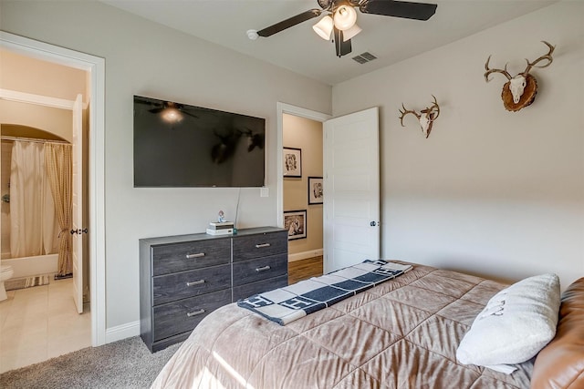 carpeted bedroom with ceiling fan and ensuite bathroom