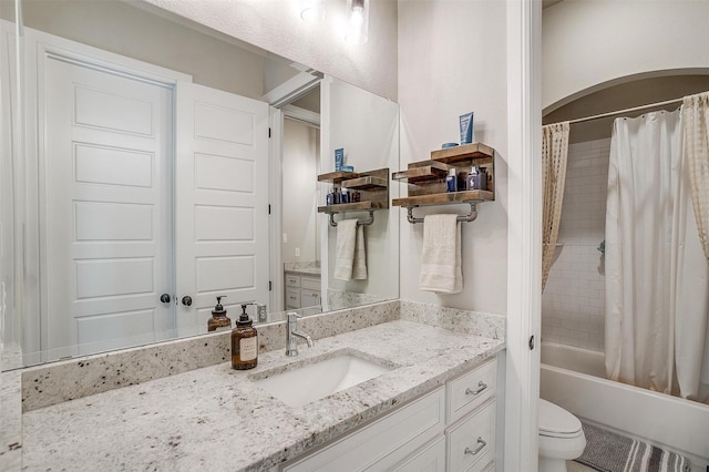 full bathroom with vanity, shower / tub combo with curtain, and toilet