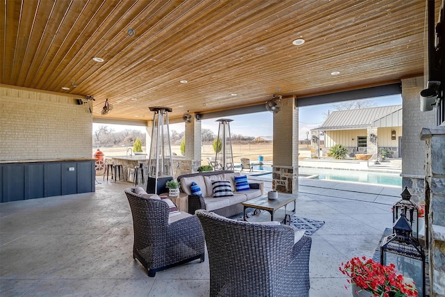 view of patio / terrace featuring a fenced in pool, exterior bar, and outdoor lounge area