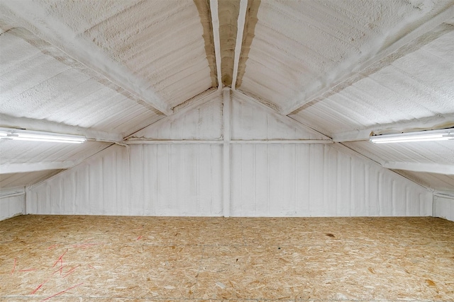 bonus room featuring vaulted ceiling with beams