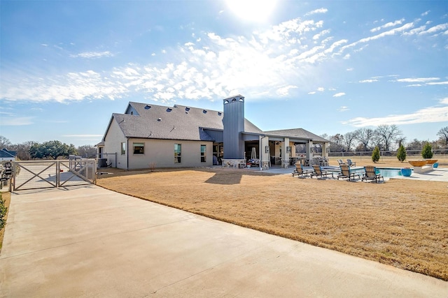 back of property featuring a fenced in pool, a patio, central AC, and a lawn