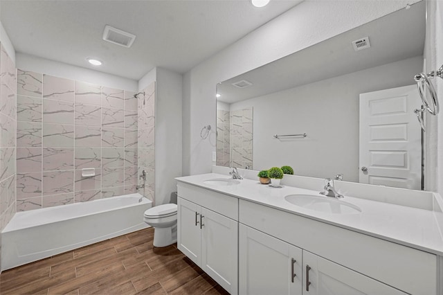 full bathroom with vanity, tiled shower / bath combo, and toilet