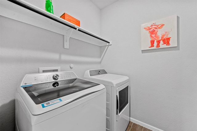 laundry area featuring separate washer and dryer and dark hardwood / wood-style flooring