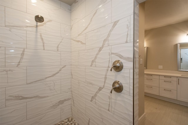 bathroom featuring a tile shower and vanity