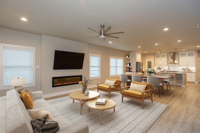 living room featuring light hardwood / wood-style flooring and ceiling fan