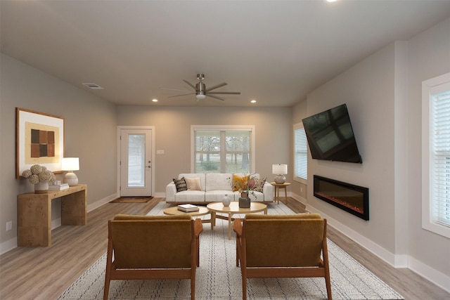 living room featuring ceiling fan and light hardwood / wood-style flooring