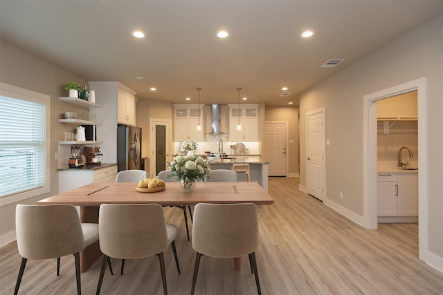 dining area featuring sink and light hardwood / wood-style flooring