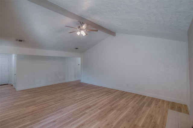 additional living space featuring ceiling fan, light hardwood / wood-style floors, a textured ceiling, and vaulted ceiling with beams