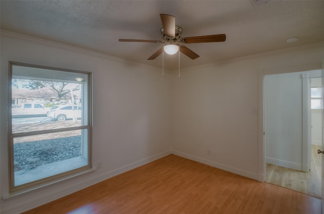 spare room featuring ceiling fan, ornamental molding, light hardwood / wood-style floors, and a textured ceiling