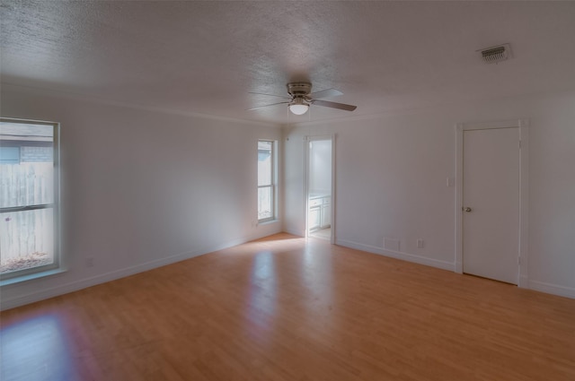 unfurnished room with crown molding, a textured ceiling, ceiling fan, and light hardwood / wood-style flooring