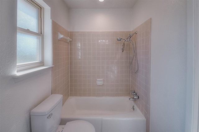 bathroom featuring tiled shower / bath and toilet