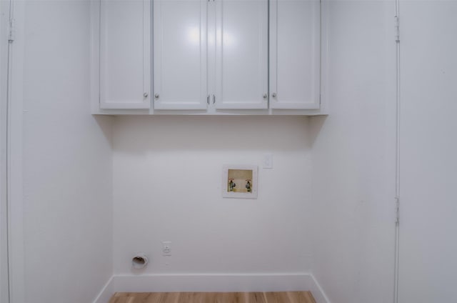 washroom featuring washer hookup, light hardwood / wood-style floors, cabinets, and hookup for an electric dryer