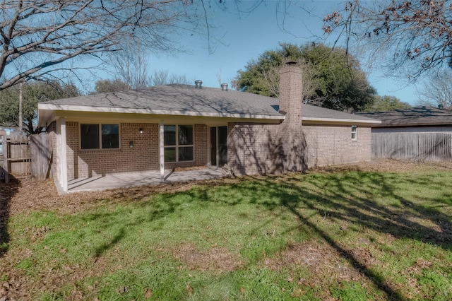 back of property with a patio area and a lawn