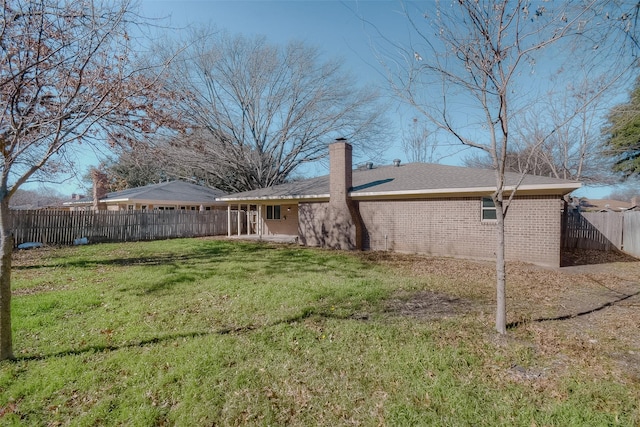 rear view of property with a lawn