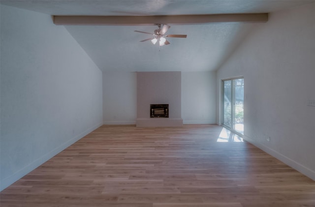 unfurnished living room featuring ceiling fan, a fireplace, lofted ceiling with beams, and light wood-type flooring