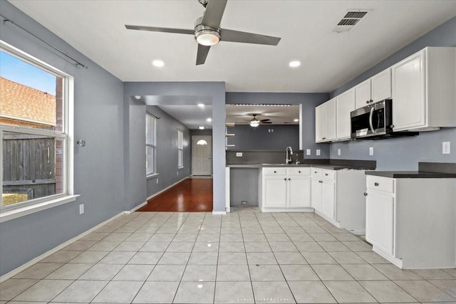 kitchen featuring white cabinetry, ceiling fan, sink, and light tile patterned floors