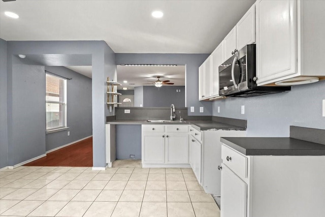 kitchen with light tile patterned flooring, sink, white cabinets, and ceiling fan