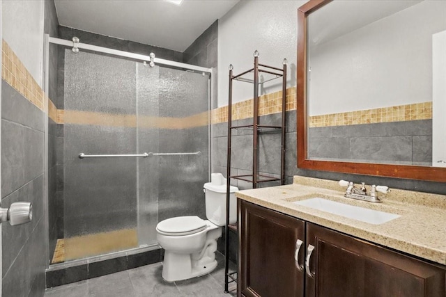 bathroom featuring walk in shower, tile walls, vanity, and toilet