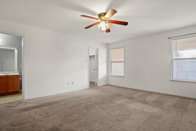 carpeted spare room featuring sink and ceiling fan