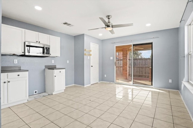 kitchen featuring light tile patterned floors, white cabinets, and ceiling fan