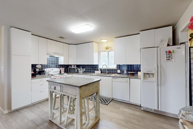 kitchen featuring white cabinetry, sink, white appliances, and backsplash