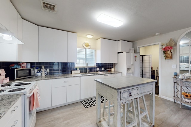 kitchen with white appliances and white cabinets