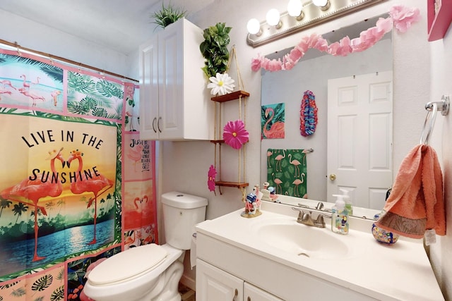 bathroom with vanity, curtained shower, and toilet