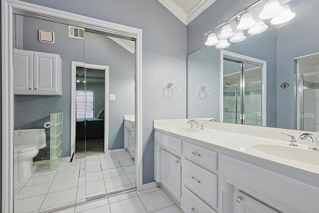 bathroom featuring tile patterned flooring, vanity, ornamental molding, toilet, and walk in shower