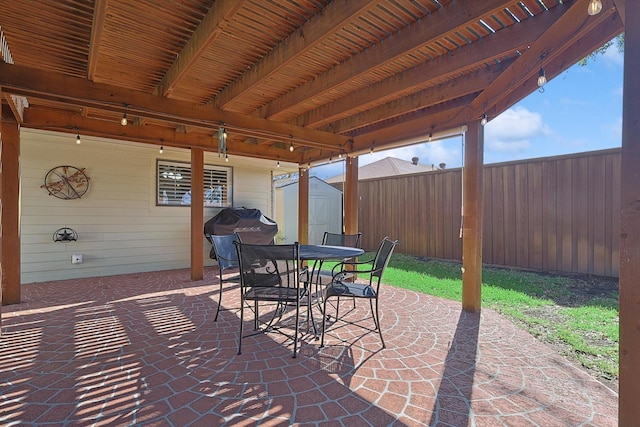 view of patio with grilling area and a storage unit