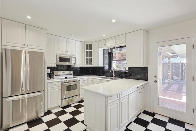 kitchen with sink, backsplash, stainless steel appliances, and white cabinets