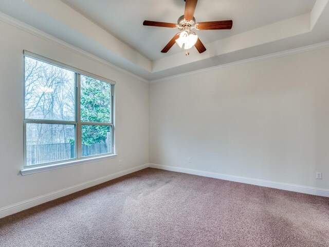 unfurnished bedroom featuring a raised ceiling, light carpet, and ensuite bath