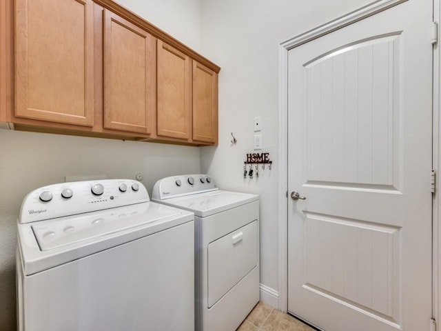 washroom featuring light tile patterned floors, cabinets, and washing machine and clothes dryer