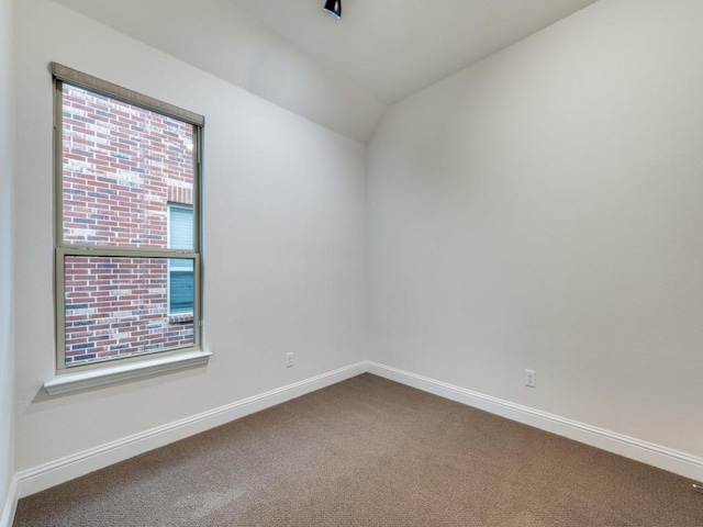 carpeted empty room with lofted ceiling