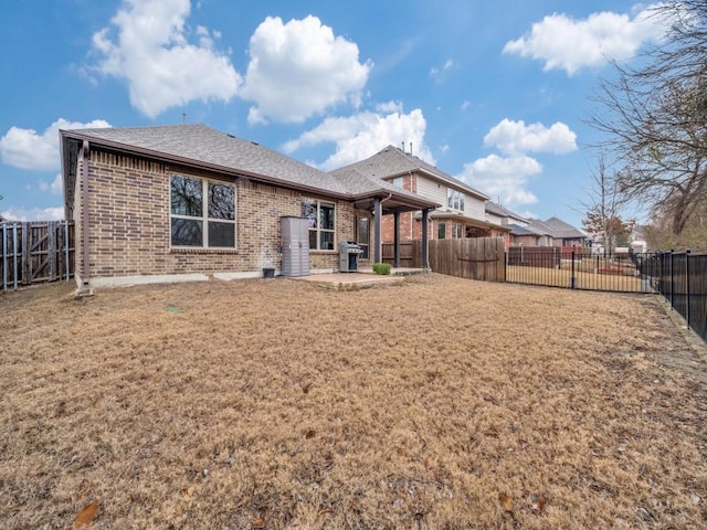 back of property with a yard and a patio area