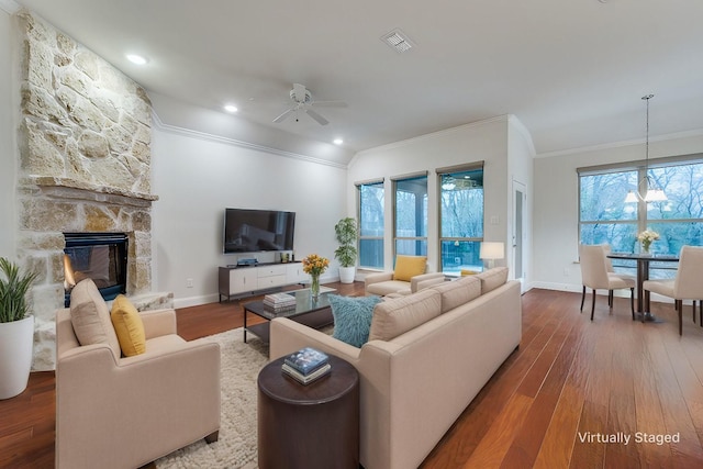 living room with ornamental molding, a healthy amount of sunlight, hardwood / wood-style floors, and a fireplace