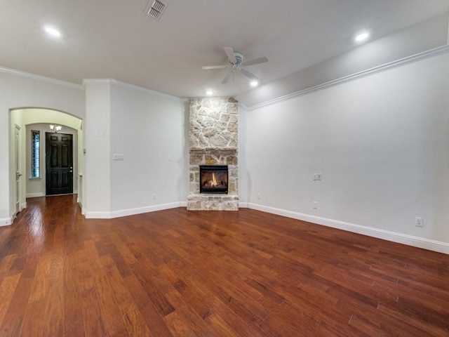 unfurnished living room with lofted ceiling, a stone fireplace, crown molding, dark hardwood / wood-style floors, and ceiling fan